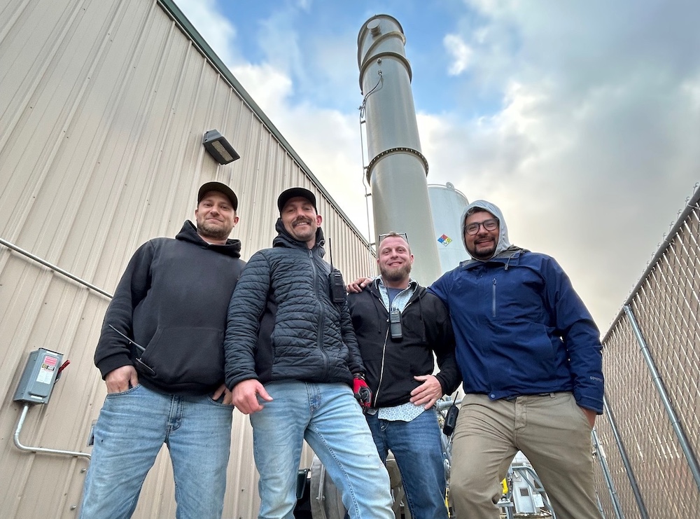 PolSys technicians posed in front of a flare